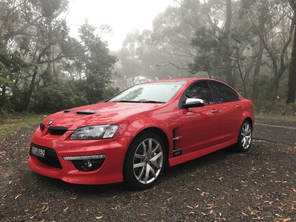 Pros-Cons-of-novated-leasing-used-car Red sports car parked on a foggy forest road.